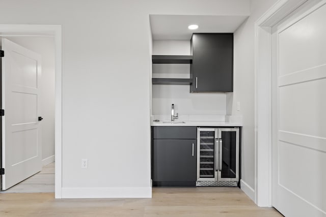 bar featuring light hardwood / wood-style floors, wine cooler, and sink