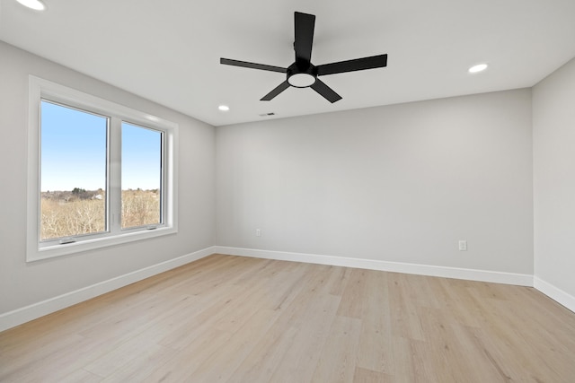 empty room with ceiling fan and light hardwood / wood-style floors