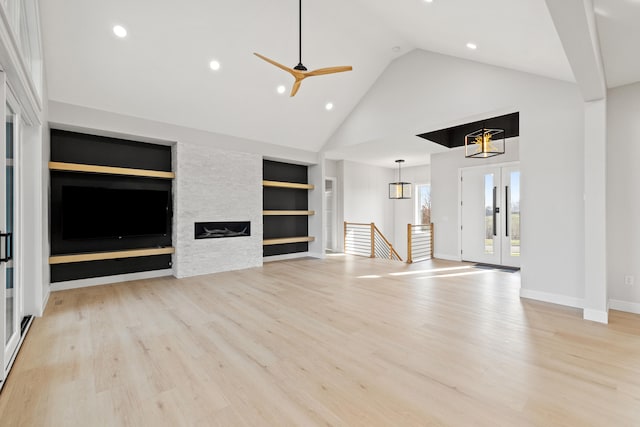 unfurnished living room featuring ceiling fan, light hardwood / wood-style floors, built in features, and a fireplace