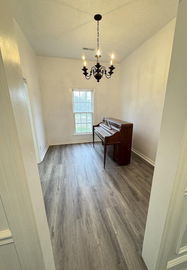 dining space featuring a chandelier, a textured ceiling, and hardwood / wood-style flooring