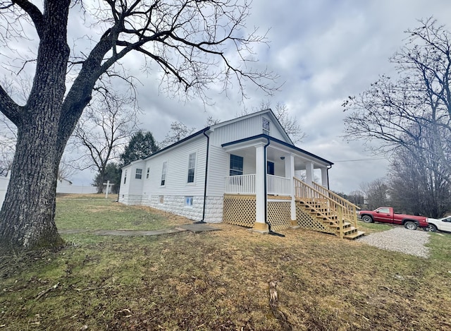 view of side of property with a porch and a yard