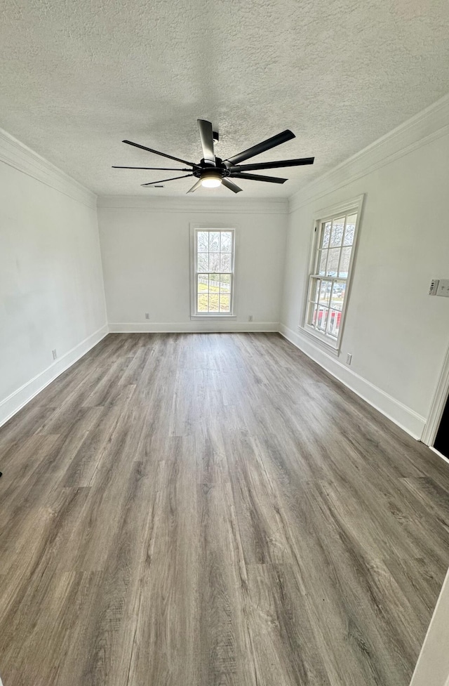 empty room with hardwood / wood-style floors, a textured ceiling, and ornamental molding