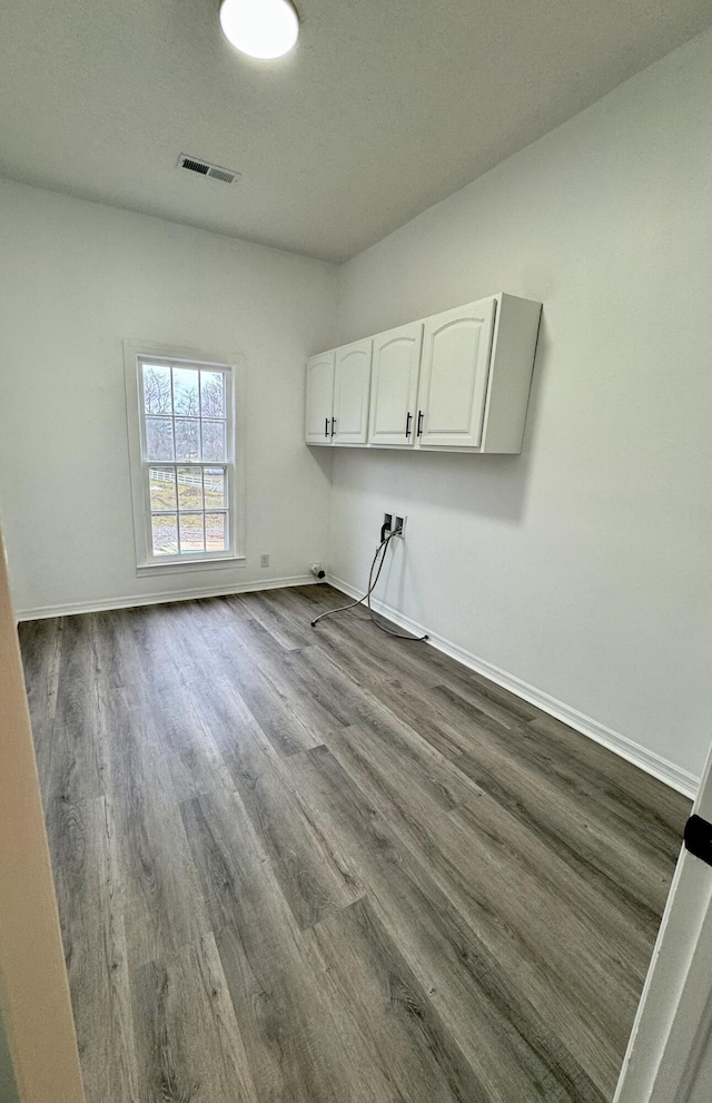 laundry room with cabinets and hardwood / wood-style flooring