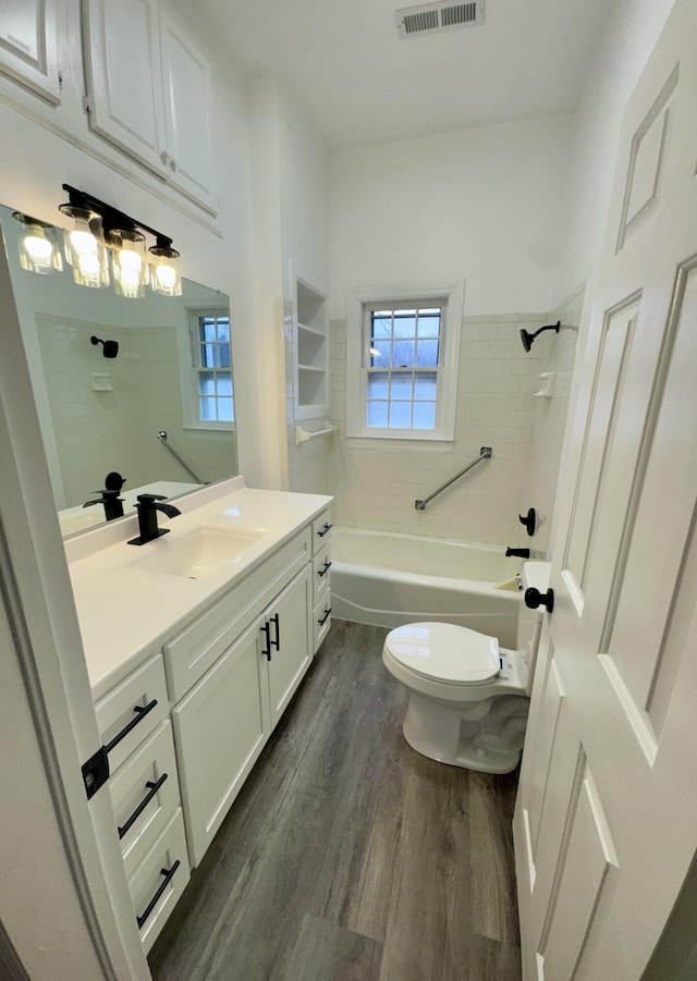 full bathroom with wood-type flooring, vanity, toilet, and tiled shower / bath