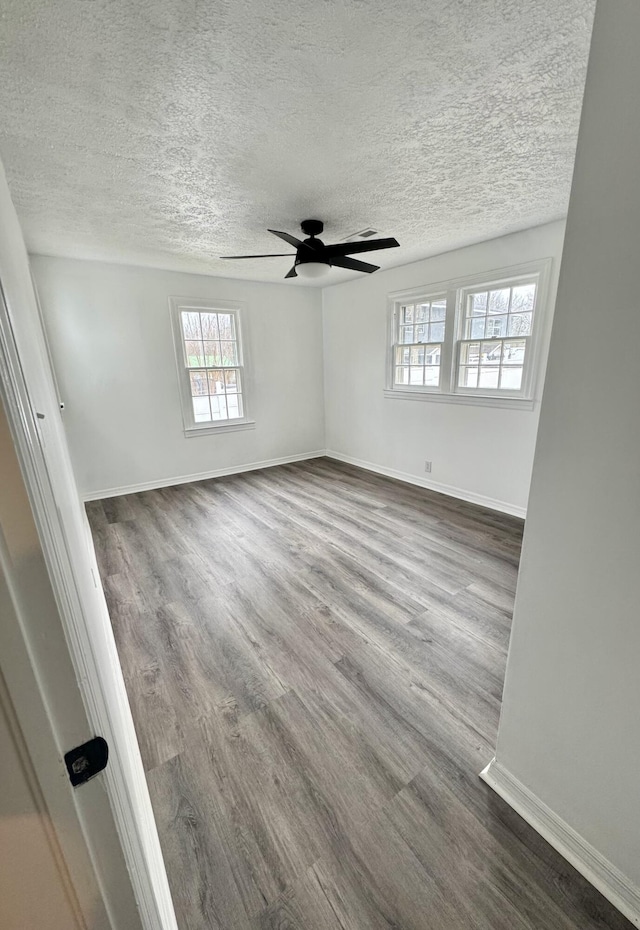 empty room featuring ceiling fan, hardwood / wood-style floors, and a textured ceiling