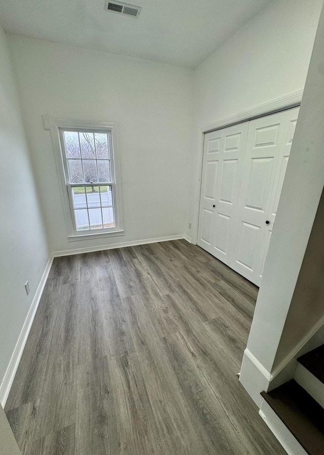 unfurnished bedroom with wood-type flooring and a closet