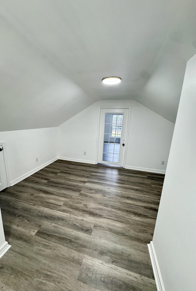 bonus room with vaulted ceiling and dark wood-type flooring