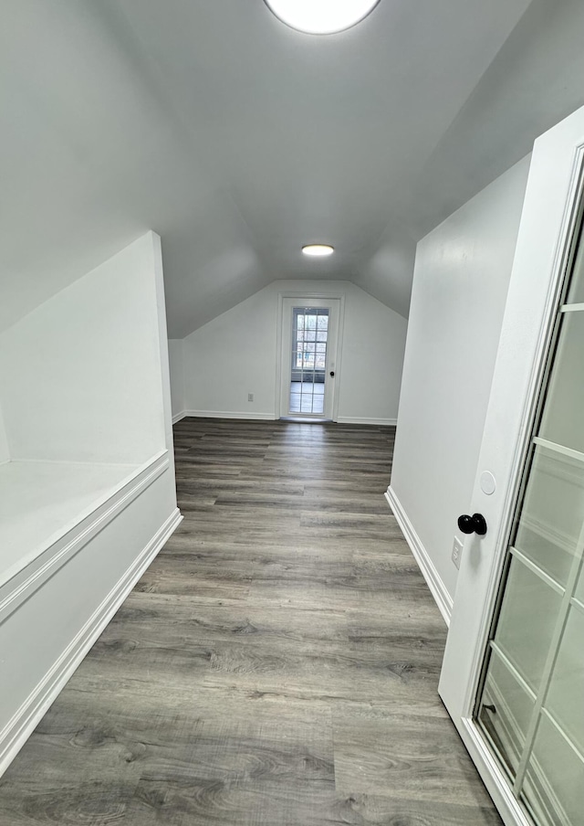 additional living space featuring dark hardwood / wood-style flooring and vaulted ceiling