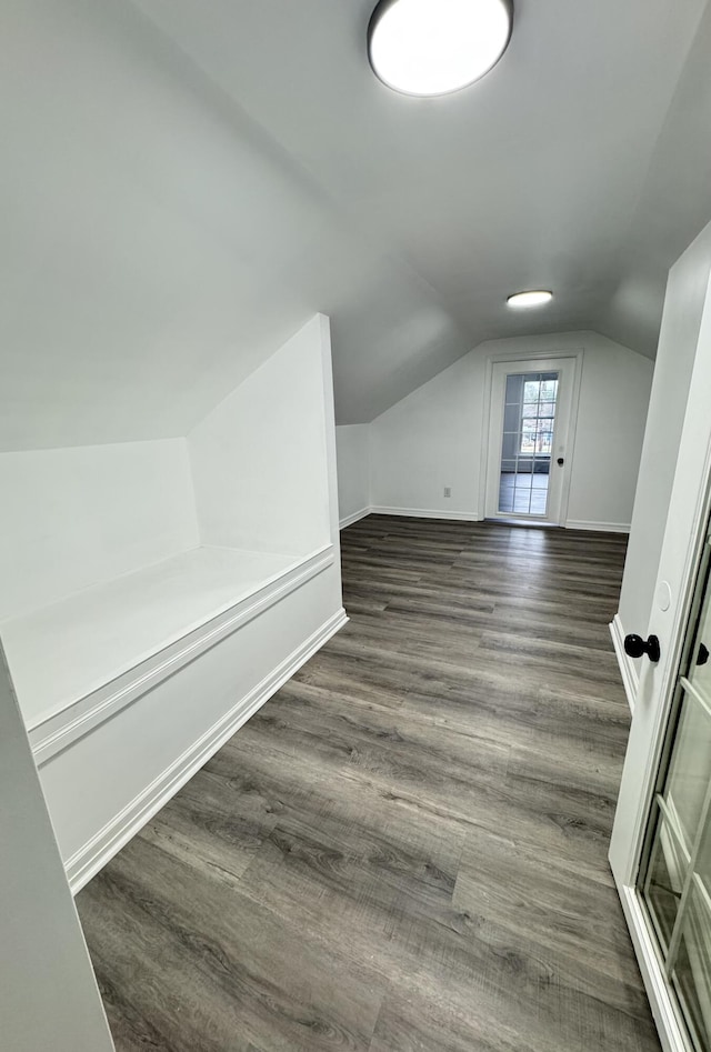 additional living space with dark hardwood / wood-style floors and vaulted ceiling