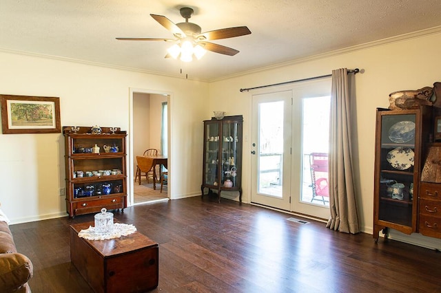 interior space with dark hardwood / wood-style floors, ceiling fan, and crown molding