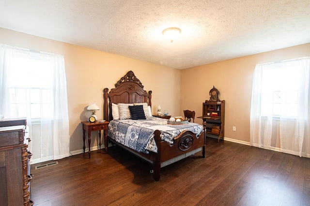 bedroom featuring a textured ceiling and dark wood-type flooring