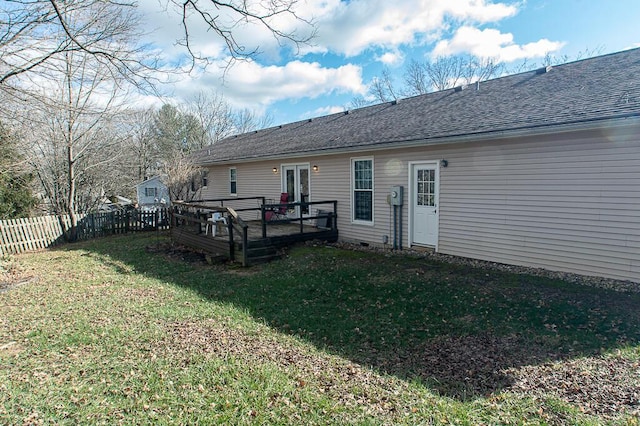 back of property with a yard and a wooden deck