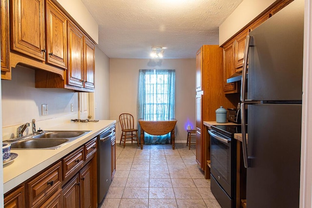 kitchen with exhaust hood, sink, light tile patterned floors, a textured ceiling, and stainless steel appliances