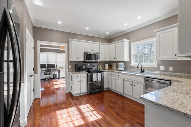 kitchen with white cabinets, light stone counters, sink, and stainless steel appliances