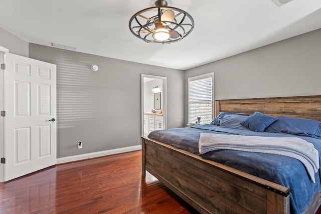 bedroom with ensuite bathroom and dark wood-type flooring