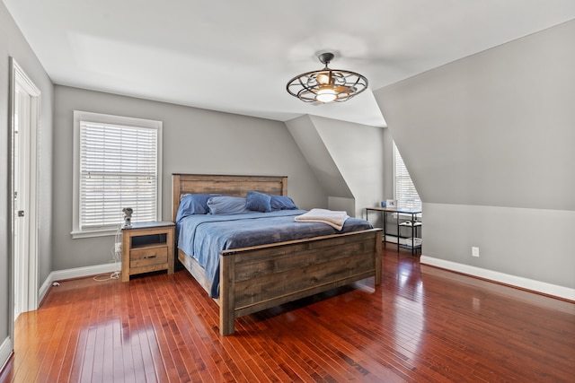 bedroom featuring vaulted ceiling, wood-type flooring, and multiple windows