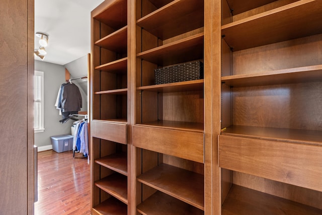 walk in closet featuring hardwood / wood-style floors and vaulted ceiling