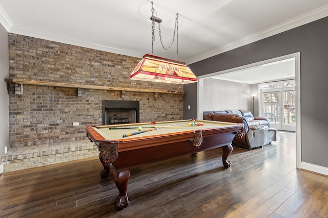 rec room with pool table, a brick fireplace, brick wall, dark hardwood / wood-style floors, and ornamental molding