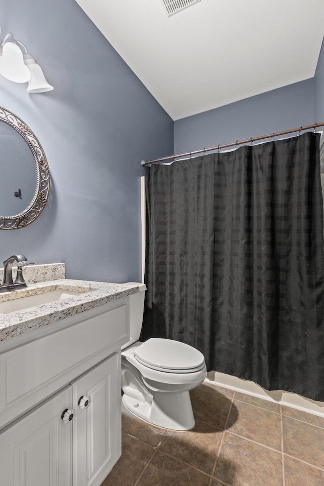 bathroom featuring tile patterned flooring, vanity, toilet, and lofted ceiling