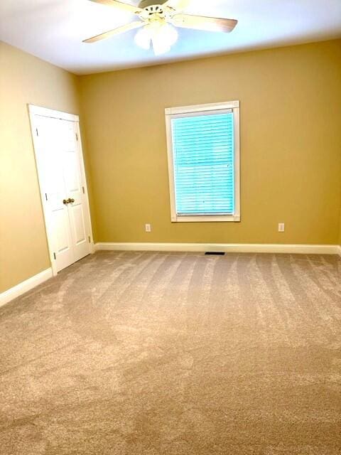 carpeted empty room featuring ceiling fan