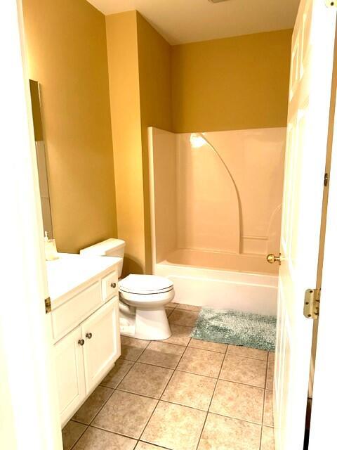 full bathroom with shower / bathing tub combination, tile patterned floors, vanity, and toilet