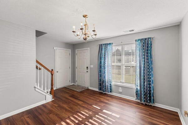 foyer featuring dark hardwood / wood-style flooring and an inviting chandelier