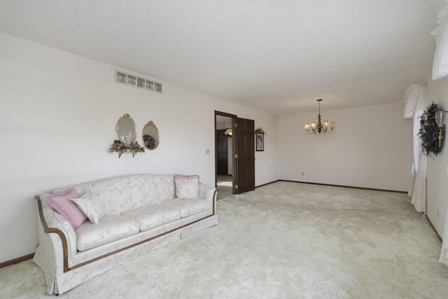 carpeted living room featuring a chandelier