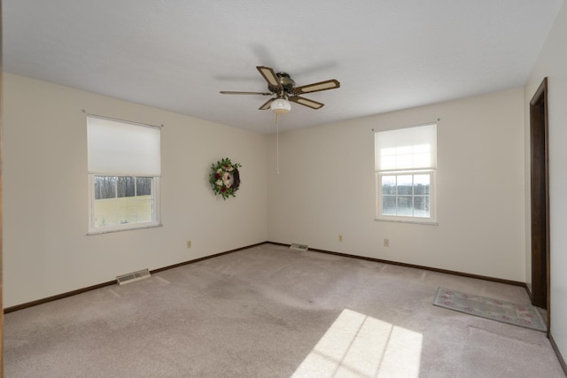 carpeted spare room featuring ceiling fan