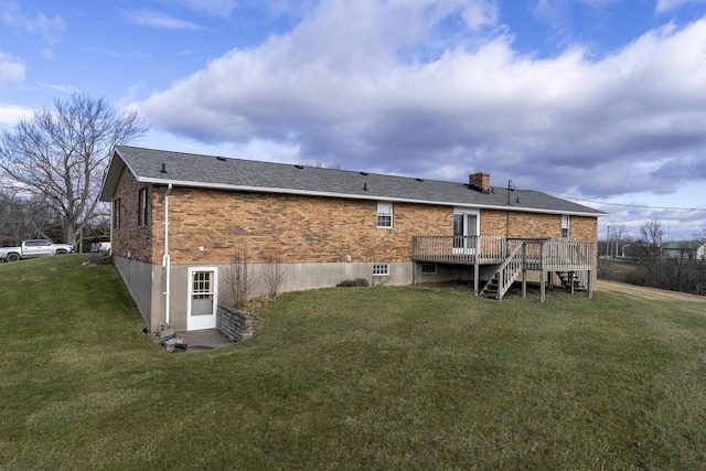 rear view of property featuring a lawn and a deck