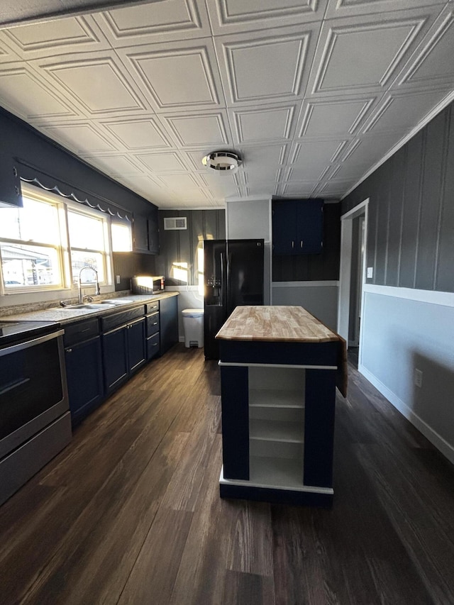 kitchen with stove, black refrigerator with ice dispenser, sink, dark hardwood / wood-style floors, and a kitchen island