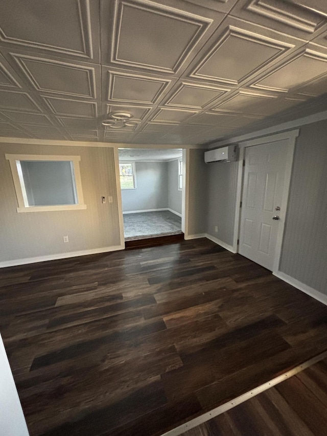 spare room featuring a wall unit AC and dark hardwood / wood-style flooring