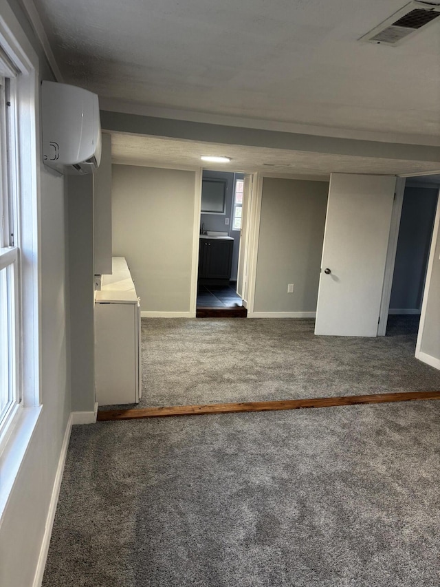 empty room with dark colored carpet and a wall mounted AC