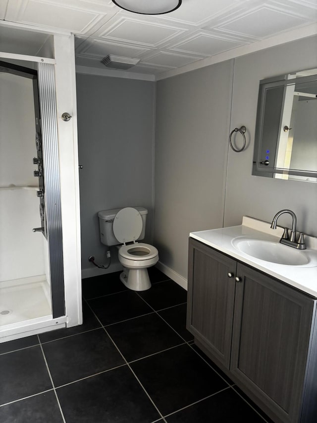 bathroom with tile patterned flooring, vanity, toilet, and walk in shower