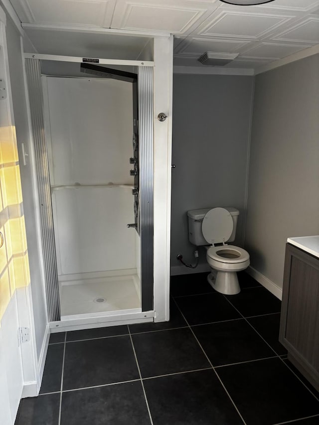 bathroom featuring a shower, vanity, tile patterned floors, and toilet