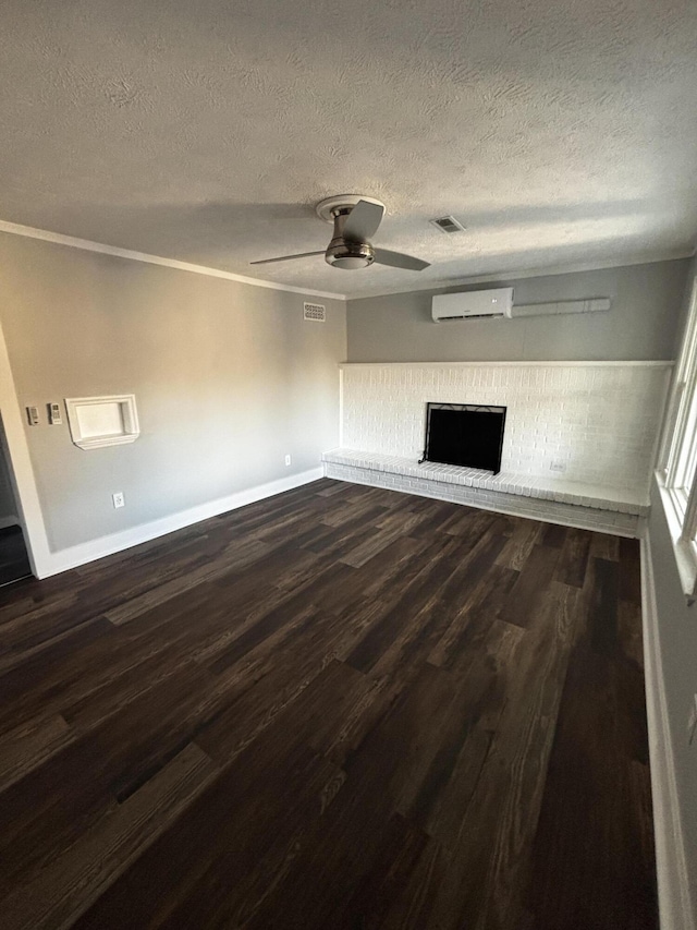 unfurnished living room featuring ceiling fan, an AC wall unit, dark wood-type flooring, and a brick fireplace