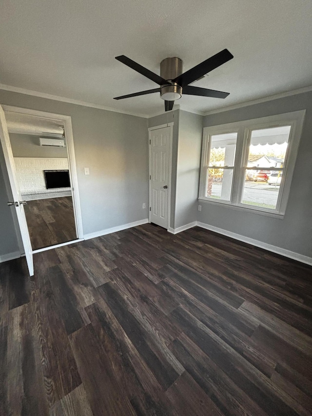 unfurnished bedroom featuring ceiling fan, dark wood-type flooring, a wall mounted AC, crown molding, and a closet