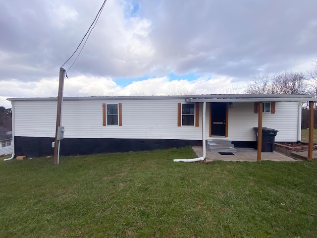 rear view of property with a yard and a patio