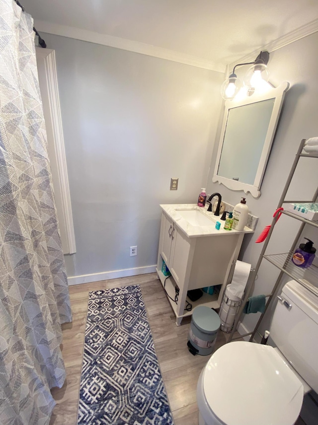 bathroom with hardwood / wood-style floors, vanity, toilet, and crown molding