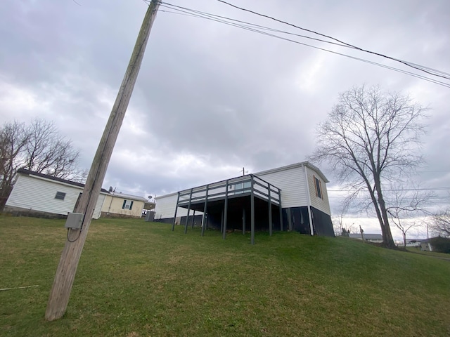 rear view of house featuring a lawn and a wooden deck