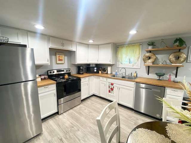 kitchen with white cabinetry, butcher block counters, sink, and appliances with stainless steel finishes