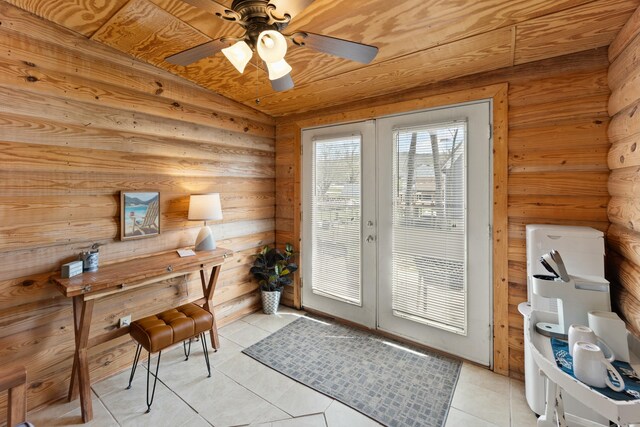 living area featuring wood walls, a ceiling fan, and tile patterned floors