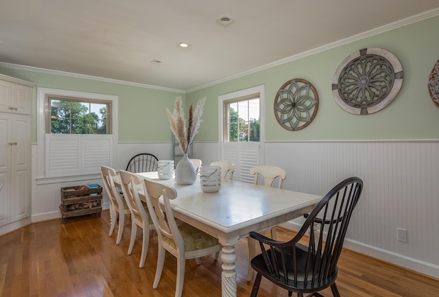 dining room with a healthy amount of sunlight, crown molding, and light hardwood / wood-style flooring