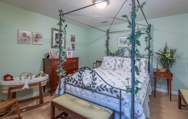 bedroom with wood-type flooring and a textured ceiling