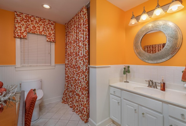 bathroom with toilet, vanity, and tile patterned floors