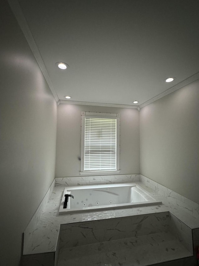 bathroom with a relaxing tiled tub and ornamental molding