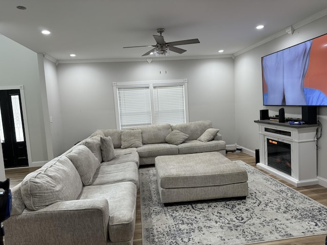 living room featuring ornamental molding, ceiling fan, and dark wood-type flooring