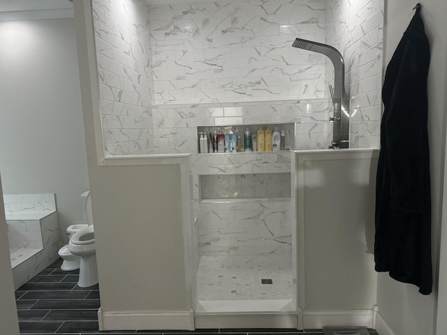 bathroom featuring toilet and tiled shower