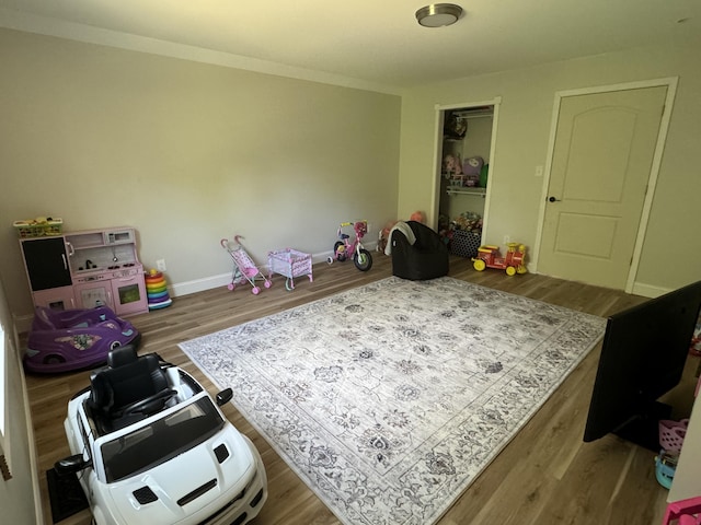 recreation room with hardwood / wood-style floors and crown molding