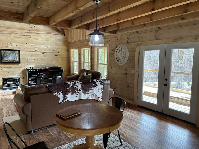 dining area featuring a wealth of natural light, french doors, wooden walls, and wood finished floors