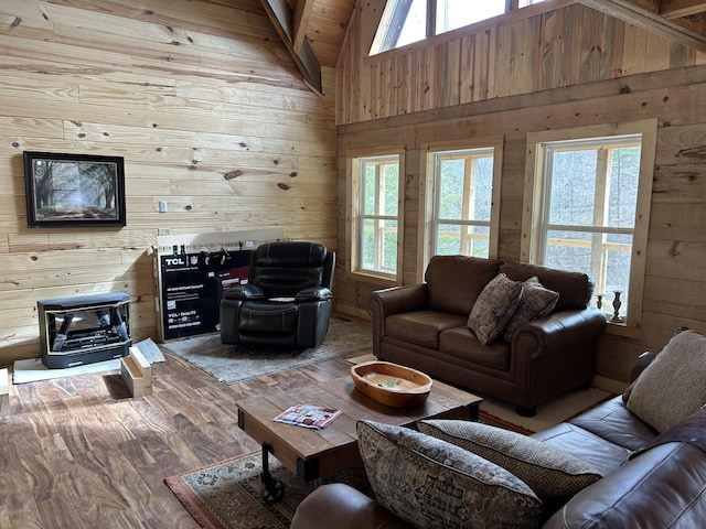 living area featuring high vaulted ceiling, a healthy amount of sunlight, and wooden walls